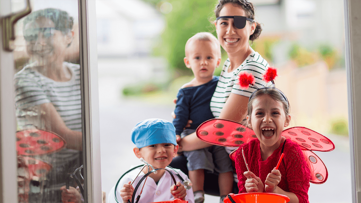 Children trick-or-treating with divorced parents ensuring a fun Halloween.