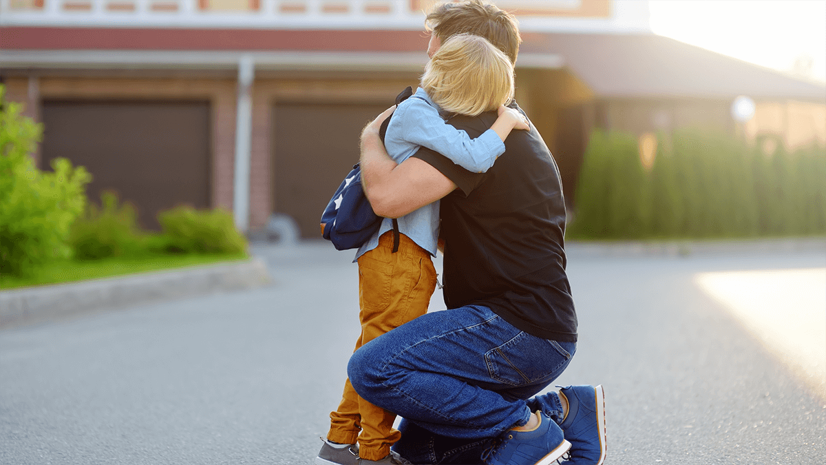 Father hugging child in front of a municipal building during a custody battle.