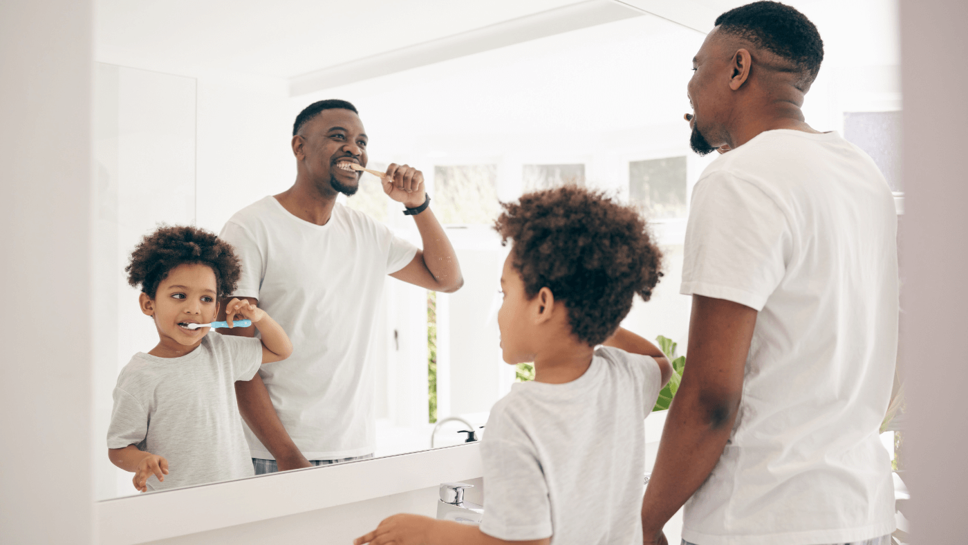 Father and child brushing teeth together, representing custody and family time